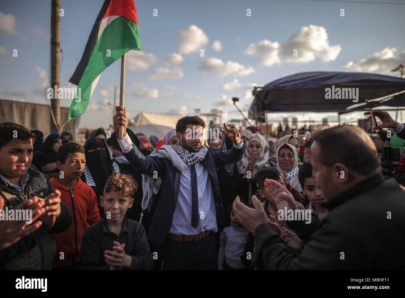 In Gaza. 10 Apr, 2018. Eine palästinensische hält eine palästinensische Flagge während einer Protestaktion in der Nähe der östlichen Grenze zwischen Gaza und Israel, am 10. April 2018. Die Masse des Protestes, der als der "Große März zurück, "Recht" der palästinensischen Flüchtlinge in ihre Häuser von Israel besetzten zurückzukehren. Credit: Wissam Nassar/Xinhua/Alamy leben Nachrichten Stockfoto