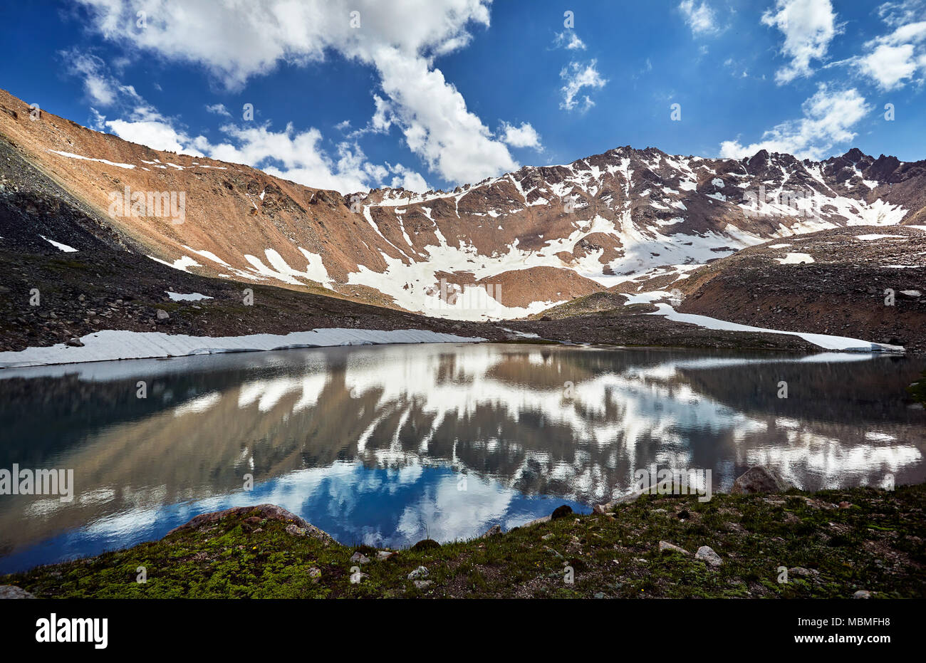 Landschaft der Bergsee mit Reflexion der schneebedeckten Gipfel mit Wolken und blauer Himmel Stockfoto