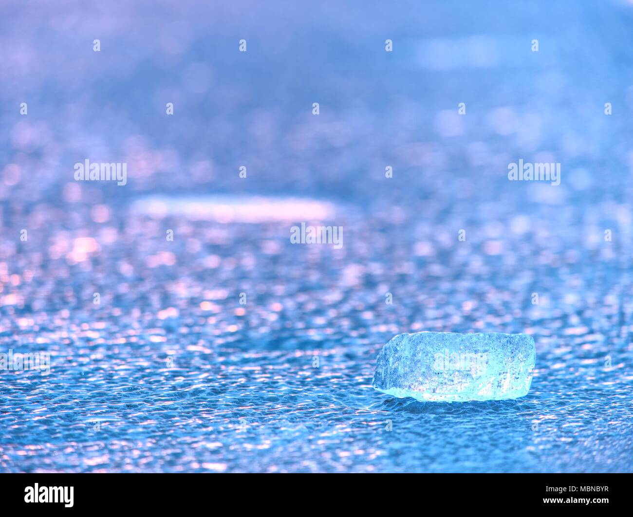 Glänzend kaltem Eis Stücke auf klare Eis. Die Struktur der natürlichen Eis in selektiven Fokus Foto. Lebendige Farben von Polar Sonnenuntergang. Stockfoto