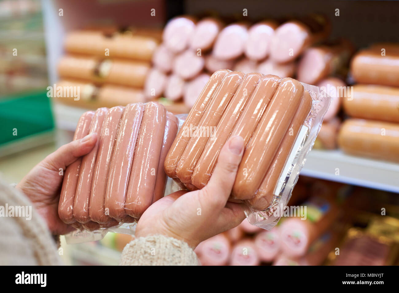 Frau entscheidet, Würstchen in einem Vakuum Paket im Lebensmittelgeschäft Stockfoto