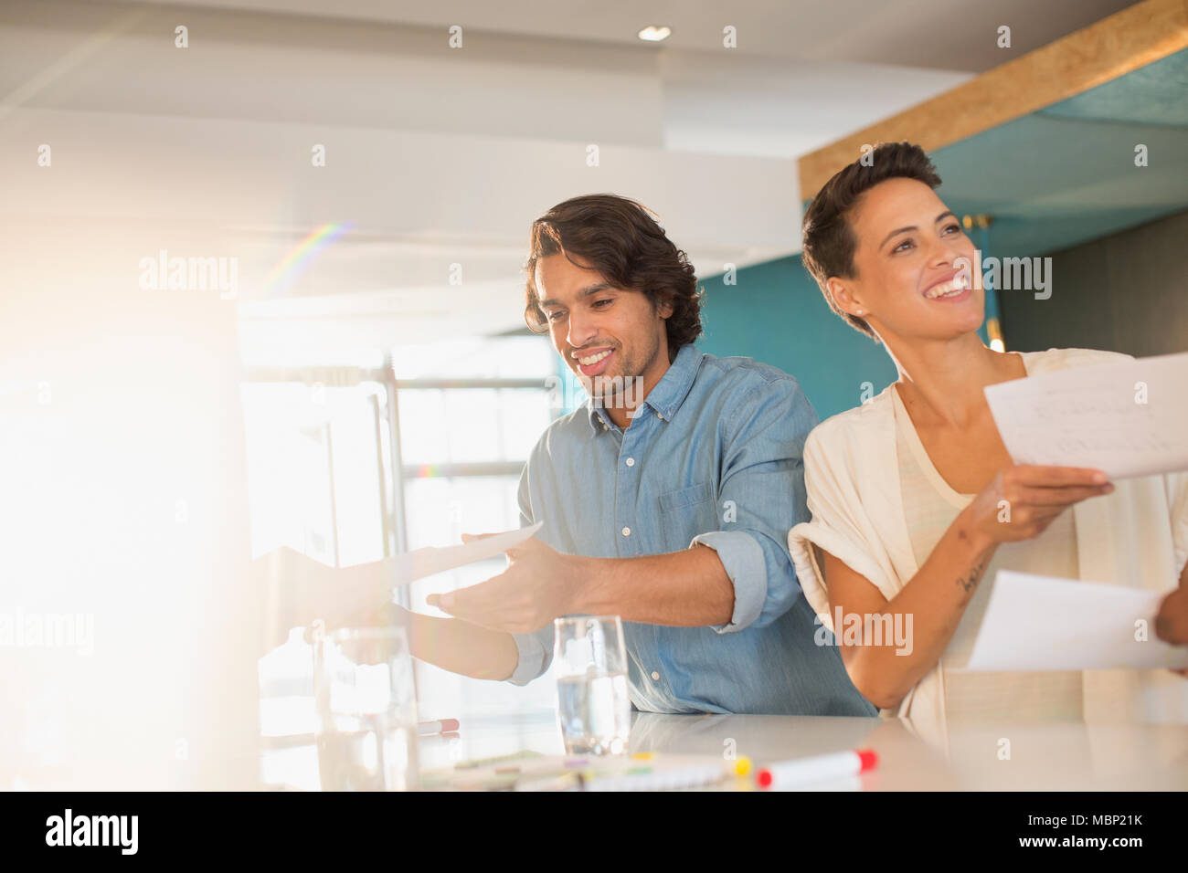 Lächelnd Geschäftsleute Brainstorming, vorbei an Schreibarbeit im Konferenzraum treffen Stockfoto
