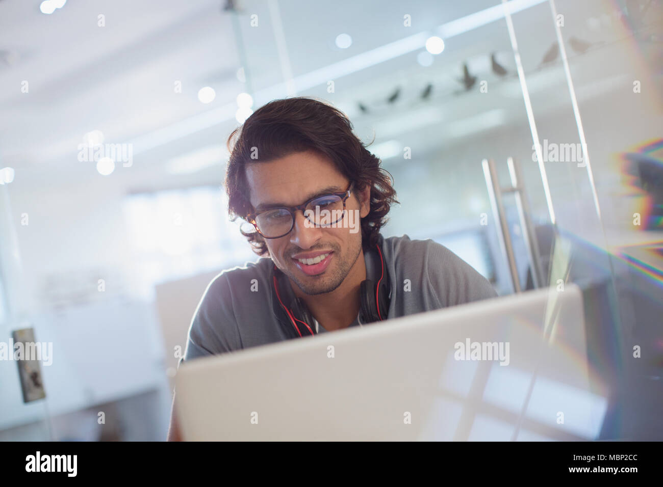 Lächelnde kreative Geschäftsmann am Laptop arbeiten Stockfoto