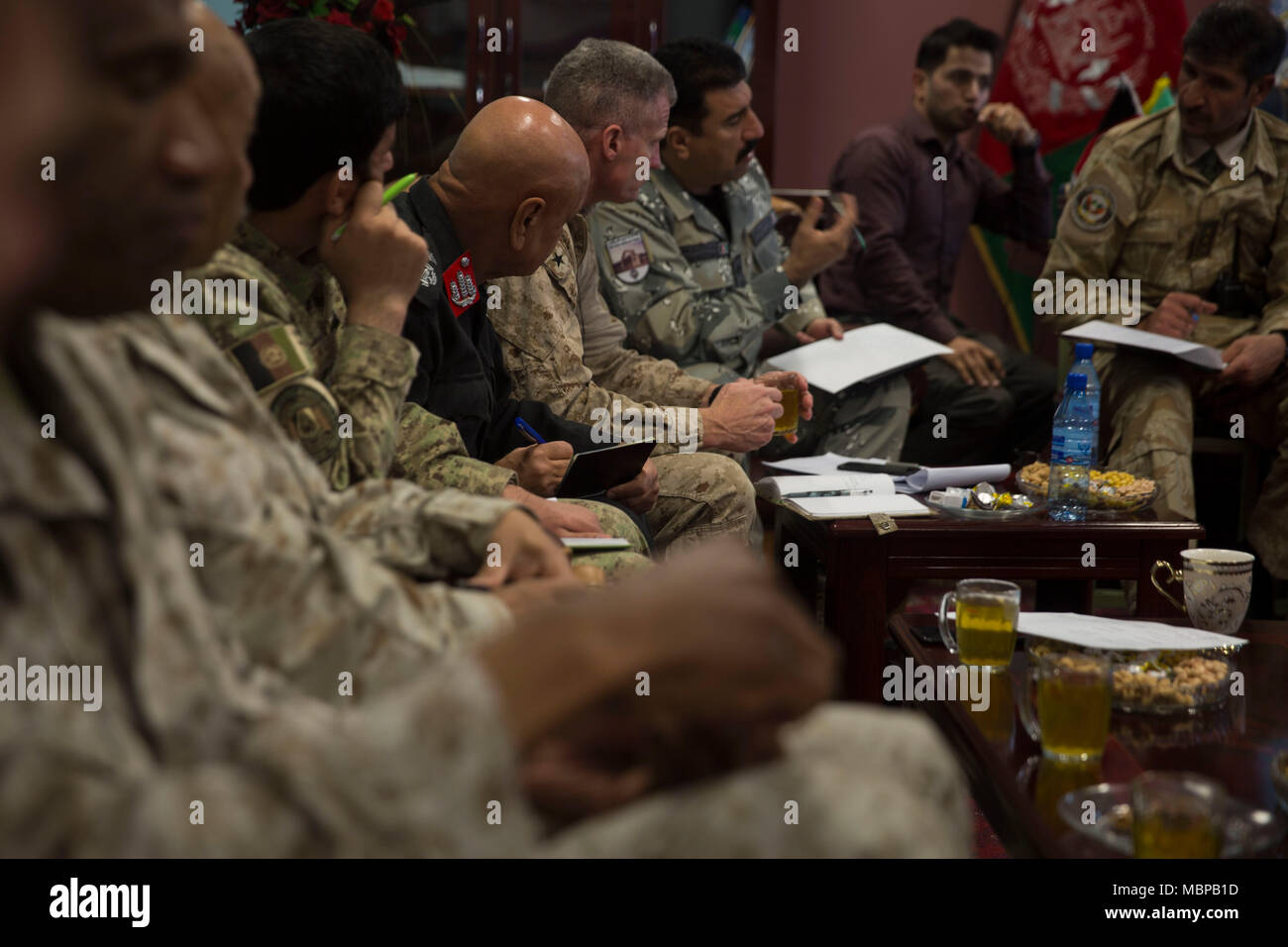 Afghanische Nationale Verteidigung und Sicherheit Kraft Führungskräfte und US-Marines mit Task Force Südwesten anhören als Brig. Gen. Daud Ghulam Tarakhel, Kommandierender General des 505Th Zone der Nationalen Polizei, erörtert die Sicherheit in der Umgebung während einer Sicherheit Shura bei Bost Flugplatz, Afghanistan, Jan. 1, 2018. Führungskräfte von Task Force Südwesten und ANDSF kamen zusammen, um zu diskutieren, Follow-on-Aktionen für maiwand 10 sowie der Provinzen Sicherheitslösungen, weitere Stärkung der Laschkar Gah Sicherheit und Stabilität in der Region. (U.S. Marine Corps Foto von Sgt. Justin T. Updegraff) Stockfoto