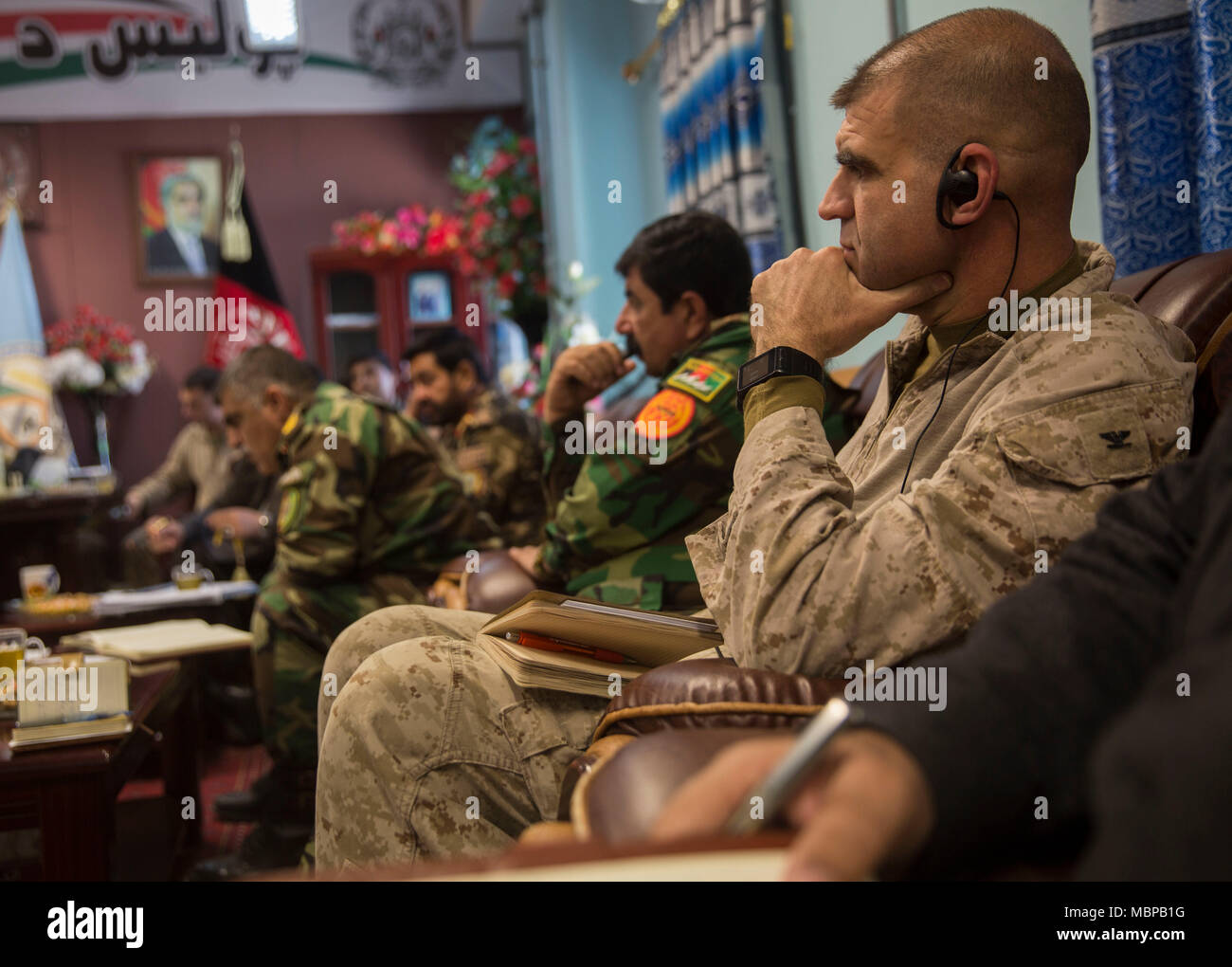 Us Marine Oberst Matthew Grosz, die Task Force Südwesten Senior Advisor des 215 Corps, hört aufmerksam während einer Sicherheit Shura bei Bost Flugplatz, Afghanistan, Jan. 1, 2018. Führungskräfte von Task Force Südwesten und der afghanischen nationalen Verteidigungs- und Sicherheitskräfte kamen zusammen, um zu diskutieren, Follow-on-Aktionen für maiwand 10 sowie der Provinzen Sicherheitslösungen, weitere Stärkung der Laschkar Gah Sicherheit und Stabilität in der Region. (U.S. Marine Corps Foto von Sgt. Justin T. Updegraff) Stockfoto