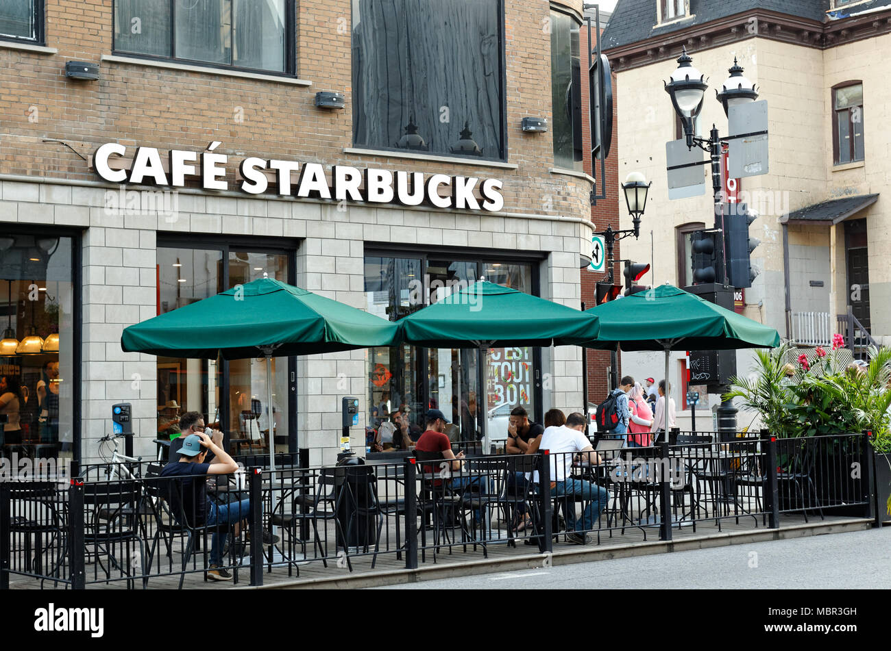 Quebec, Kanada. Die Leute auf dem Bürgersteig Terrasse von Starbucks Cafe auf St-Denis Street in der Innenstadt von Montreal sitzen. Stockfoto