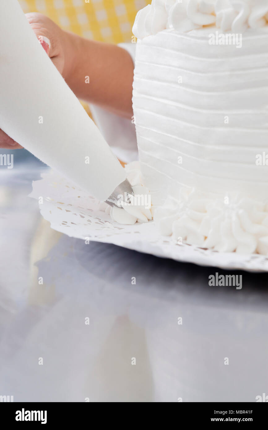 Frau Vereisung Kuchen in der Gewerblichen Küche Stockfoto