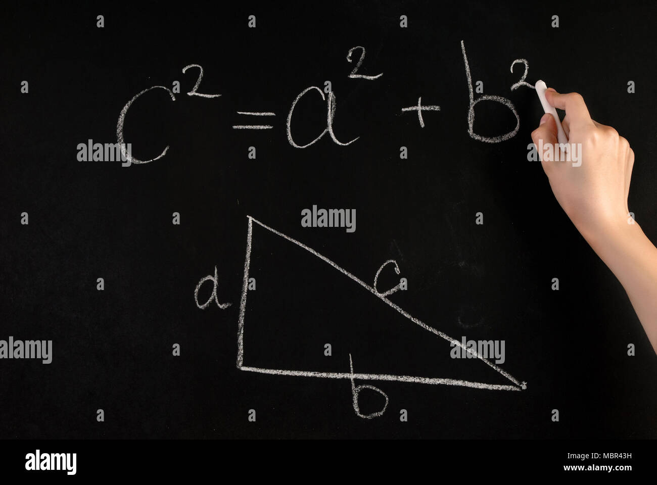 Mädchen Hand schreiben Pythagoras Formel und rechtwinkligen Dreieck mit auf Schule Tafel mit weißer Kreide Stockfoto