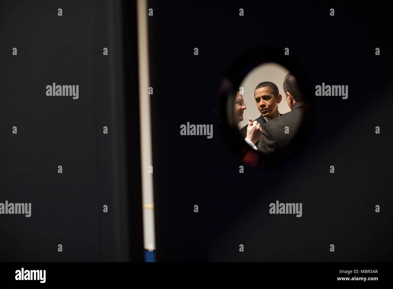 Präsident Barack Obama wird durch eine ovale Fenster gesehen, wie er sich mit leitenden Mitarbeitern Robert Gibbs, links, und David Axelrod nach einer Pressekonferenz auf dem G20-Gipfel im ExCel Centre in London trifft. Offiziellen White House Photo by Pete Souza Stockfoto