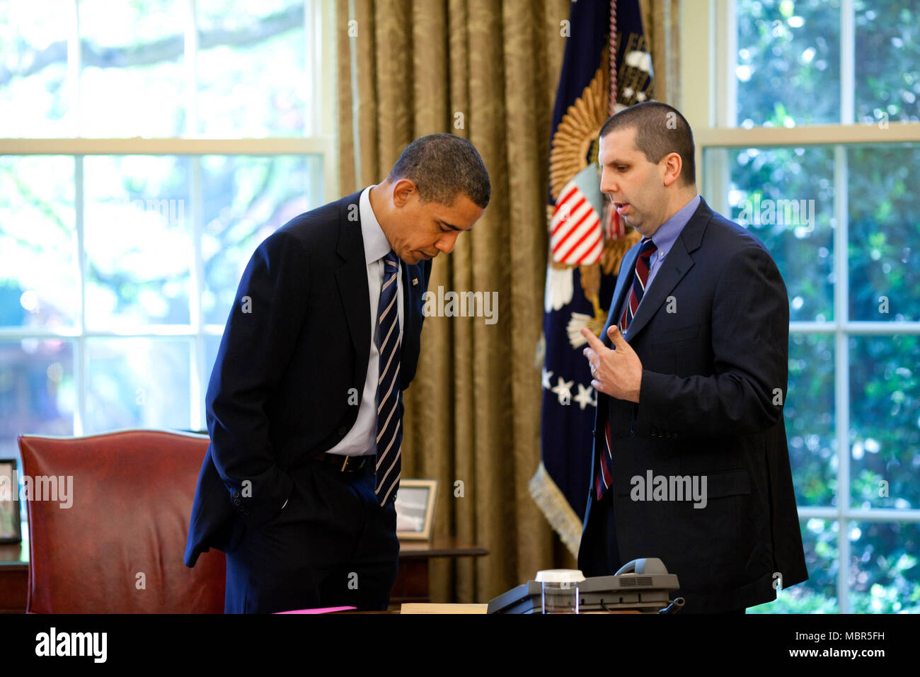 Präsident Barack Obama spricht mit Mark Lippert, Chief-of-Mitarbeiter im Nationalen Sicherheitsrat, im Oval Office vor, um einen Anruf mit gewählter Präsident Jacob Zuma von Südafrika. Offizielle Weiße Haus Foto von Pete Souza. Stockfoto