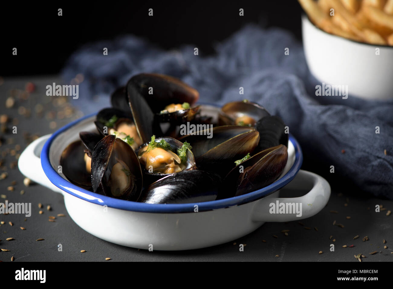 Moules - Pommes frites, Muscheln und Pommes frites, die typisch für Belgien, auf einem rustikalen Holztisch Stockfoto