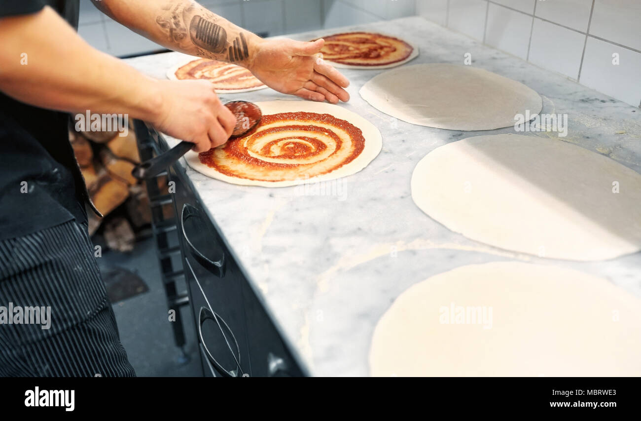 Kochen mit Tomatensoße, Pizza in der Pizzeria Stockfoto