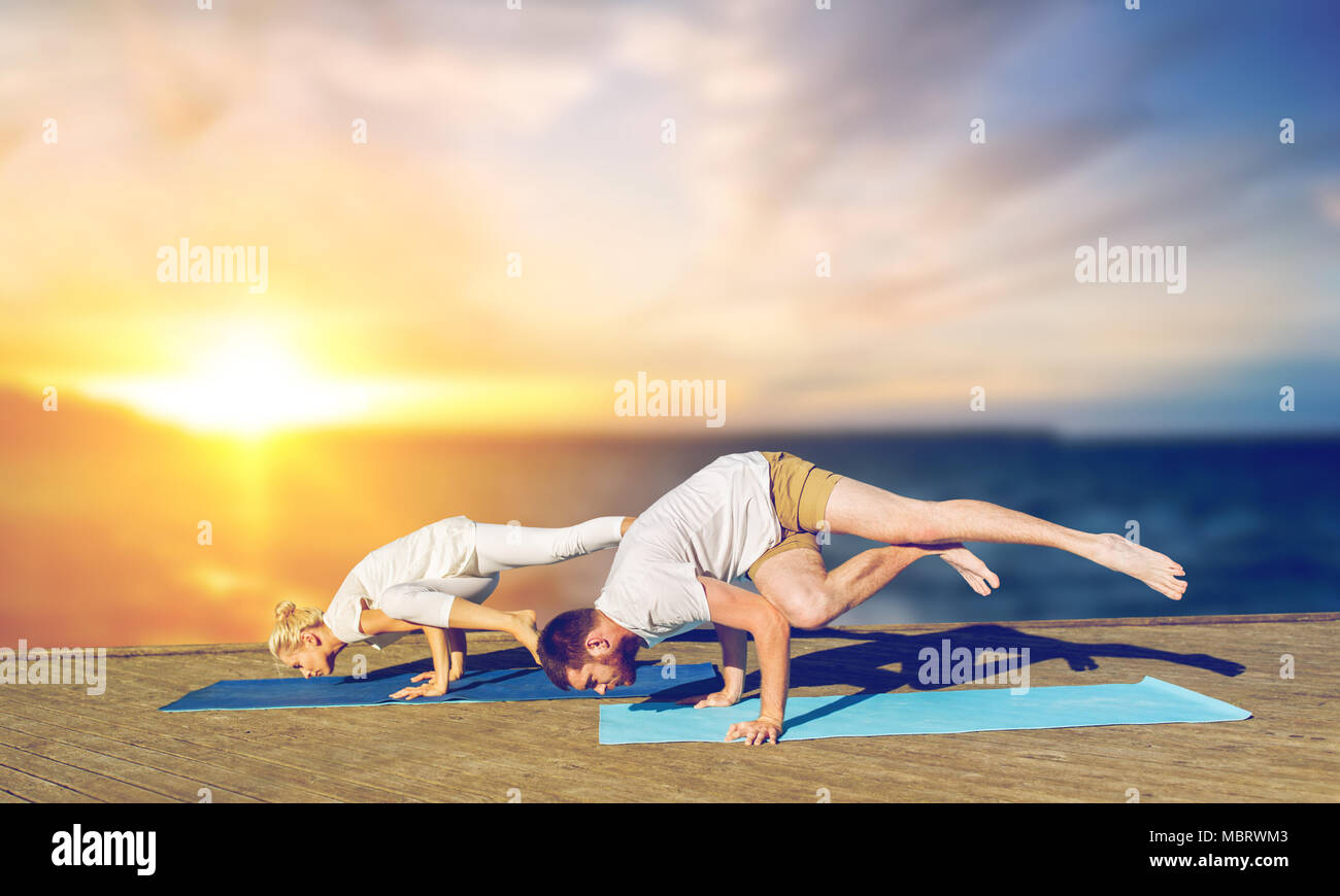 Paar yoga Seite Kran stellen im Freien Stockfoto