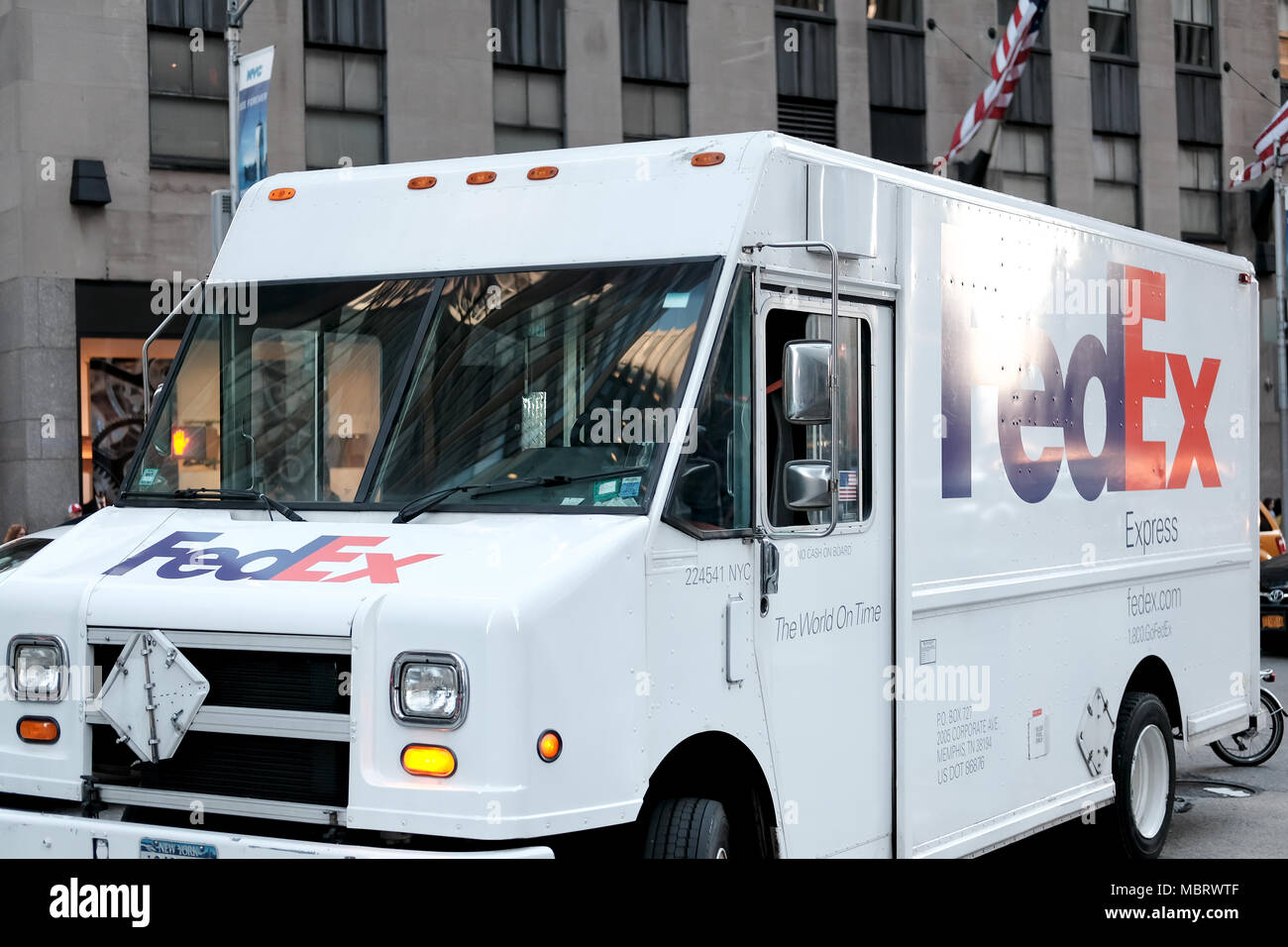 - Abstellen, auch internationalen Kurierdienst Auto außerhalb einer großen finanziellen Gebäude im Zentrum von New York City zu sehen, über die ein Paket zu liefern. Stockfoto
