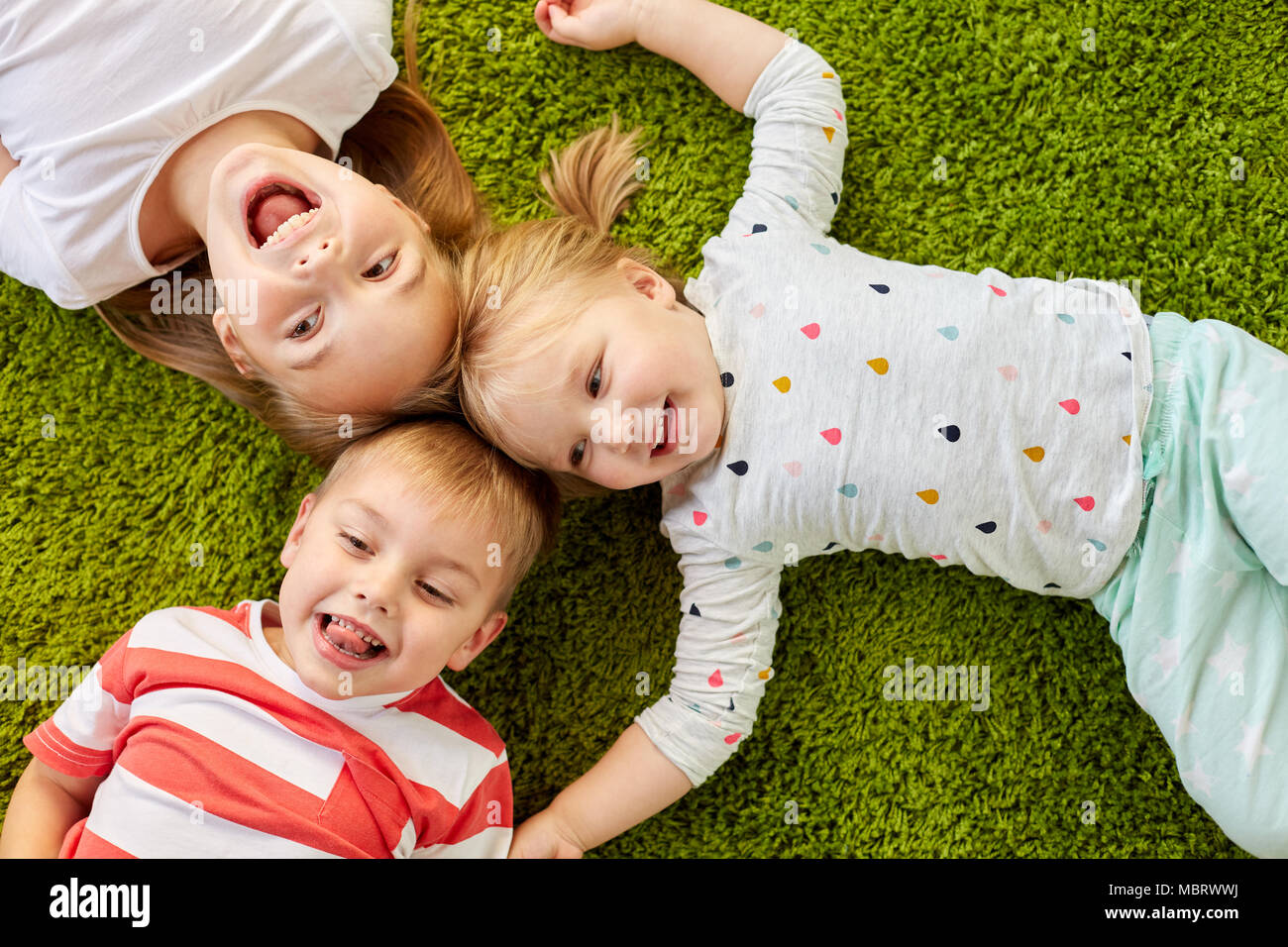 Gerne kleine Kinder liegen auf dem Boden oder Teppich Stockfoto