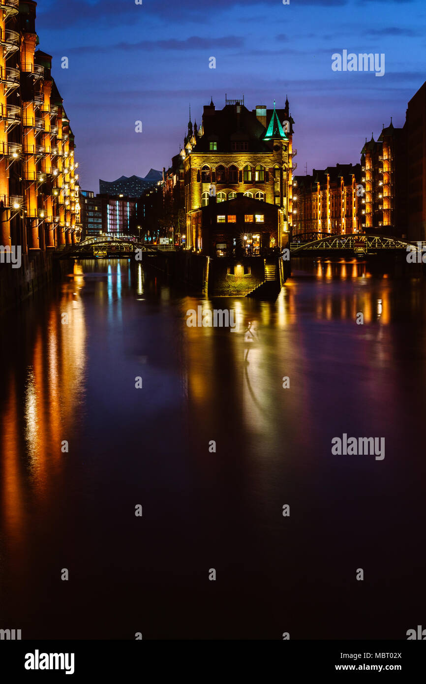 Die Speicherstadt - Speicherstadt in der Dämmerung. Tourismus Wahrzeichen von Hamburg. Blick auf Wandrahmsfleet im Licht der Laterne Lampe. Der Hamburger Hafen in der HafenCity Quartal Stockfoto