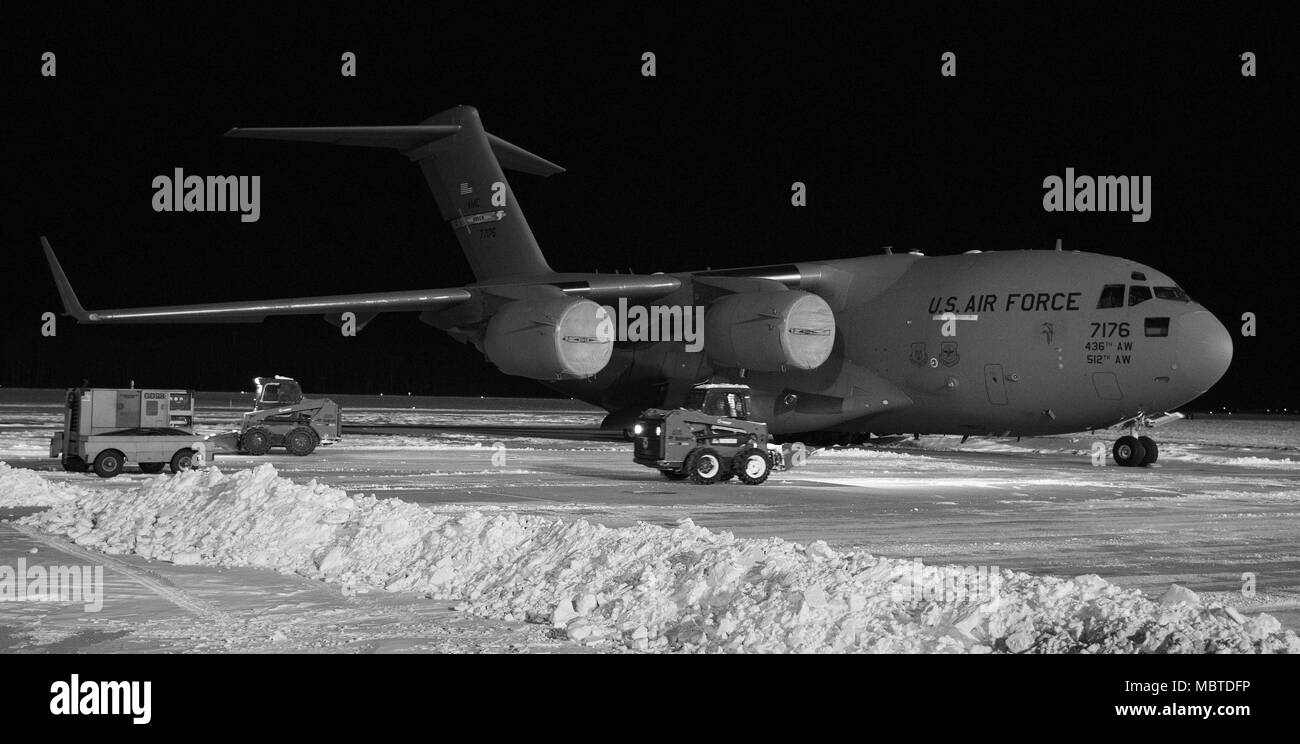 Wartungspersonal von der 736th Aircraft Maintenance Squadron verwenden Bobcats zu Schnee um ein C-17A Globemaster III, Jan. 5, 2018, in Dover Air Force Base, Del Der 436Th Operations Support Squadron wetter Flug acht Zoll Schnee aufgezeichneten fiel auf der Basis von Wintersturm Grayson. (U.S. Air Force Foto von Roland Balik) Stockfoto