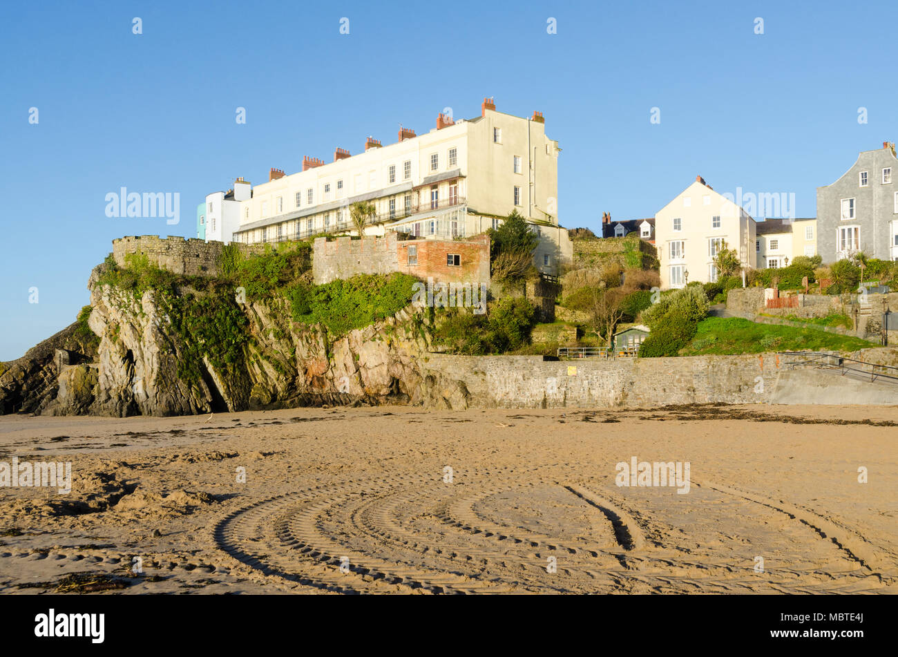 Bunte Häuser mit Blick auf Castle Beach, Tenby am frühen Morgen Sonnenschein Stockfoto