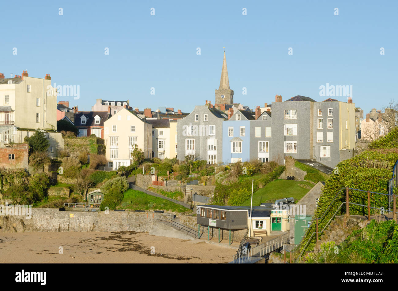 Bunte Häuser mit Blick auf Castle Beach, Tenby am frühen Morgen Sonnenschein Stockfoto