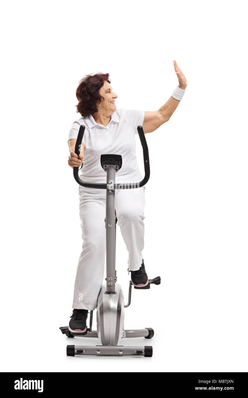 Ältere Frau Training auf einem stationären Fahrrad und einen hohen - fünf Geste auf weißem Hintergrund Stockfoto