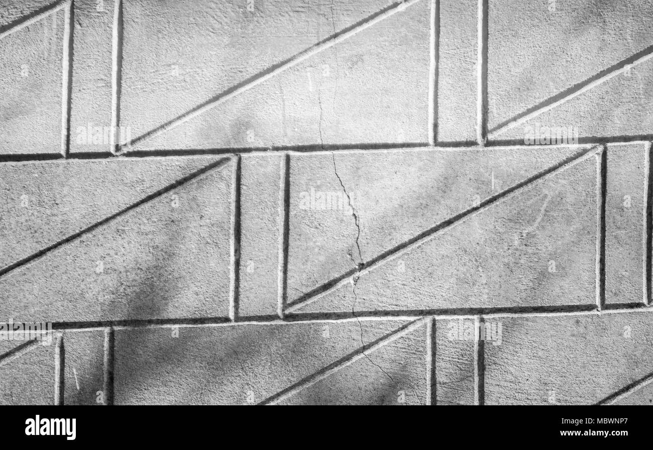 Graue Betonwand Textur mit diagonal Schwarz relief Linien Stockfoto