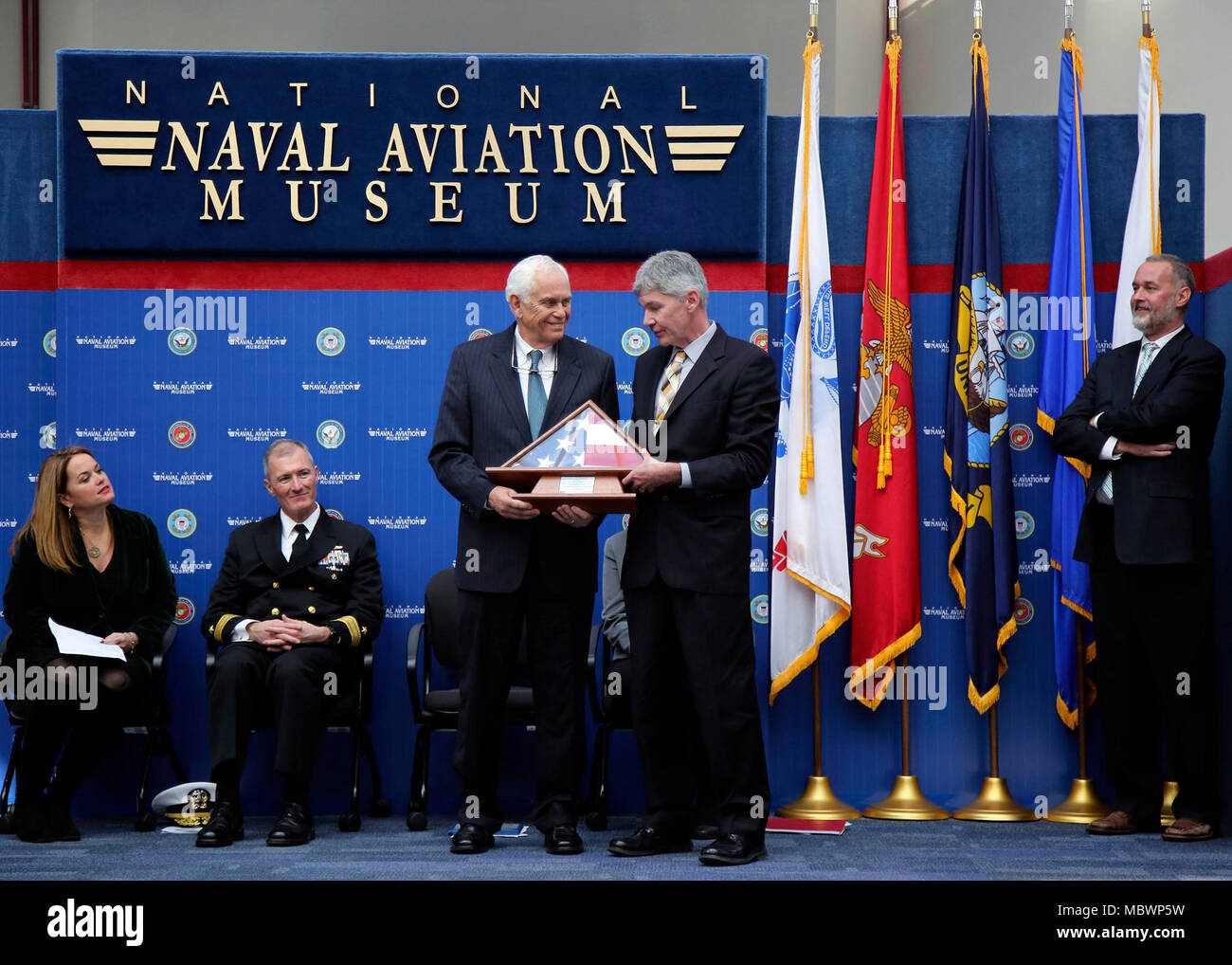 180105-N-PU 674-079 Pensacola, Fla. (Jan. 5, 2018) Dr. J. D. Smith, Links, erhält eine Flagge von seinem Personal- spezialist, Rick Kokr während seinen Ruhestand Feierstunde im National Naval Aviation Museum, Naval Air Station Pensacola, Fla. Smith in der Regierung für mehr als 44 Jahre gedient, darunter 17 Jahre als Programmdirektor für die Marine Junior Reserve Officer Training Corps (Njrotc) Programm, das betont Staatsbürgerschaft und Leadership Development, sowie das maritime Erbe, die Bedeutung der Sea Power, und die Marine Themen wie die Grundlagen der Marineoperationen, Seemannschaft, naviga Stockfoto