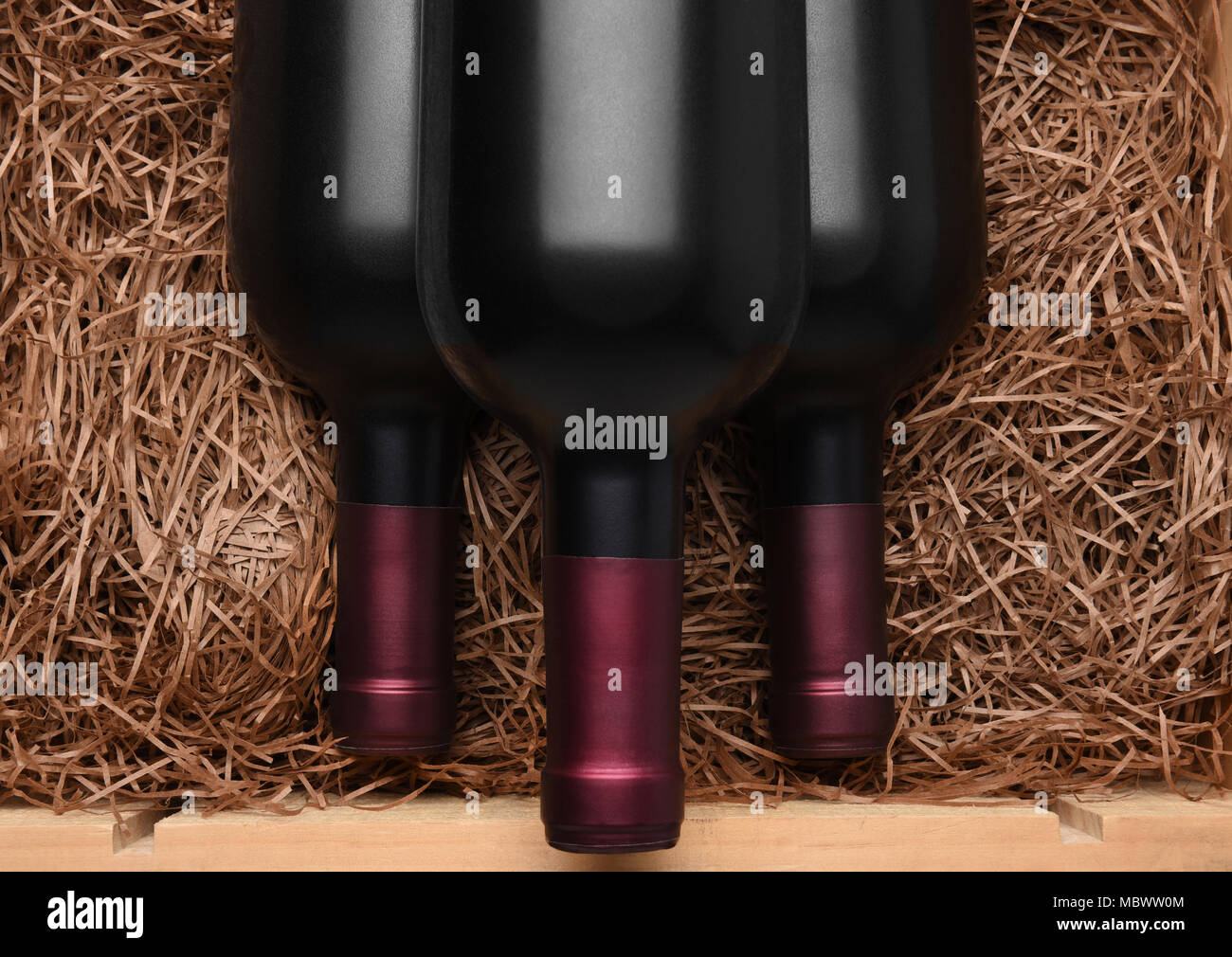 Drei Cabernet Flaschen: Drei Flaschen Rotwein in einem Wald bei Verpackung Stroh. Stockfoto