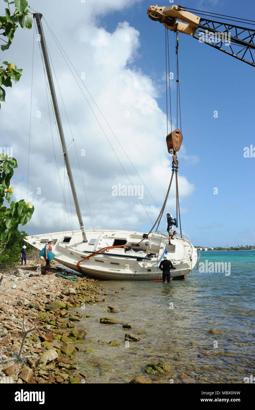 Coast Guard Mitglieder der Marine lösen Gruppe, eine vertraglich festgelegte Antwort Unternehmen überwachen, da sie ein verlassenes Schiff vom Ufer des Muller Bay, St. Thomas, Virgin Islands, als Teil der Emergency Support Funktion 10 Antwort, Jan. 13, 2018. Die Küstenwache ist hier, den US-Jungferninseln Abteilung der Planung und natürlichen Ressourcen verlassene Schiffe, die von den Hurrikanen Irma und Maria als Teil der ESF-10 Operationen verdrängt zu entfernen. Coast Guard Foto von Petty Officer 1st Class Gina Ruoti Stockfoto