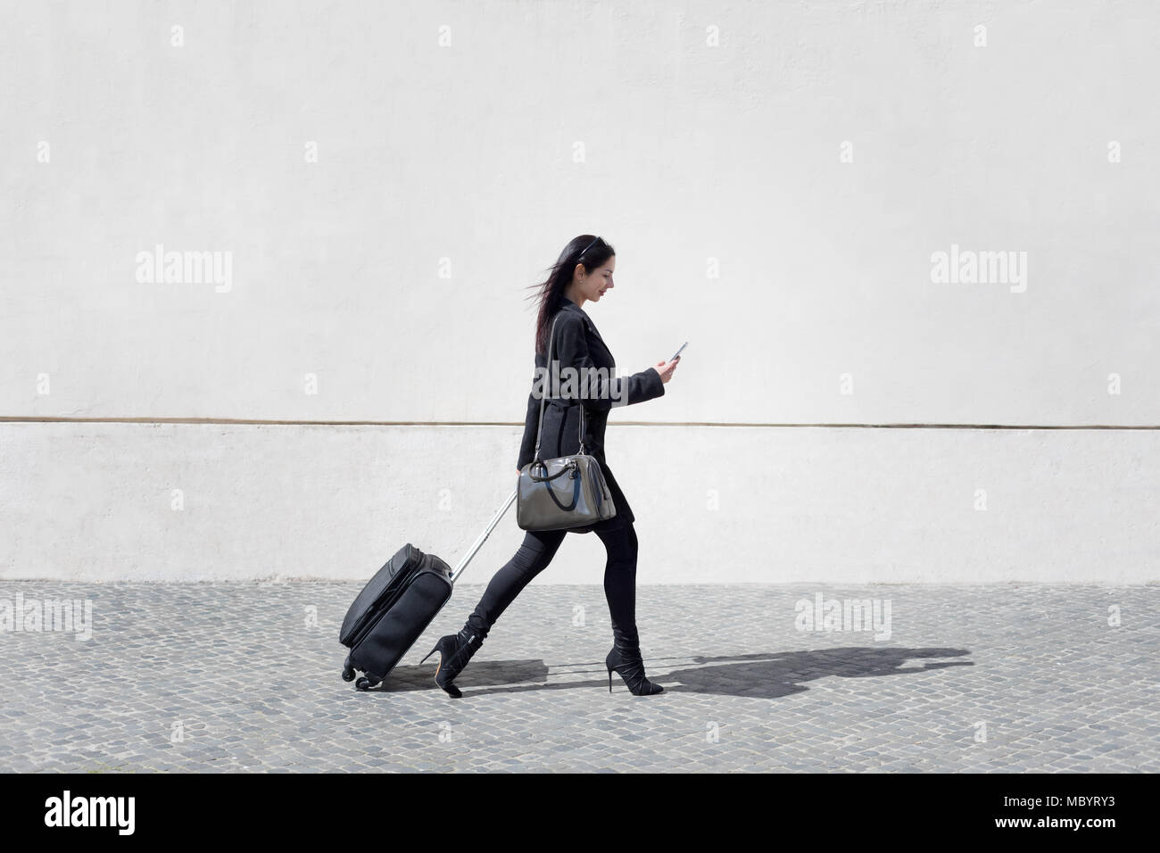 Vorstand und moderne Frau geht die Straße mit Ihrem Gepäck, während Sms das  Handy Stockfotografie - Alamy