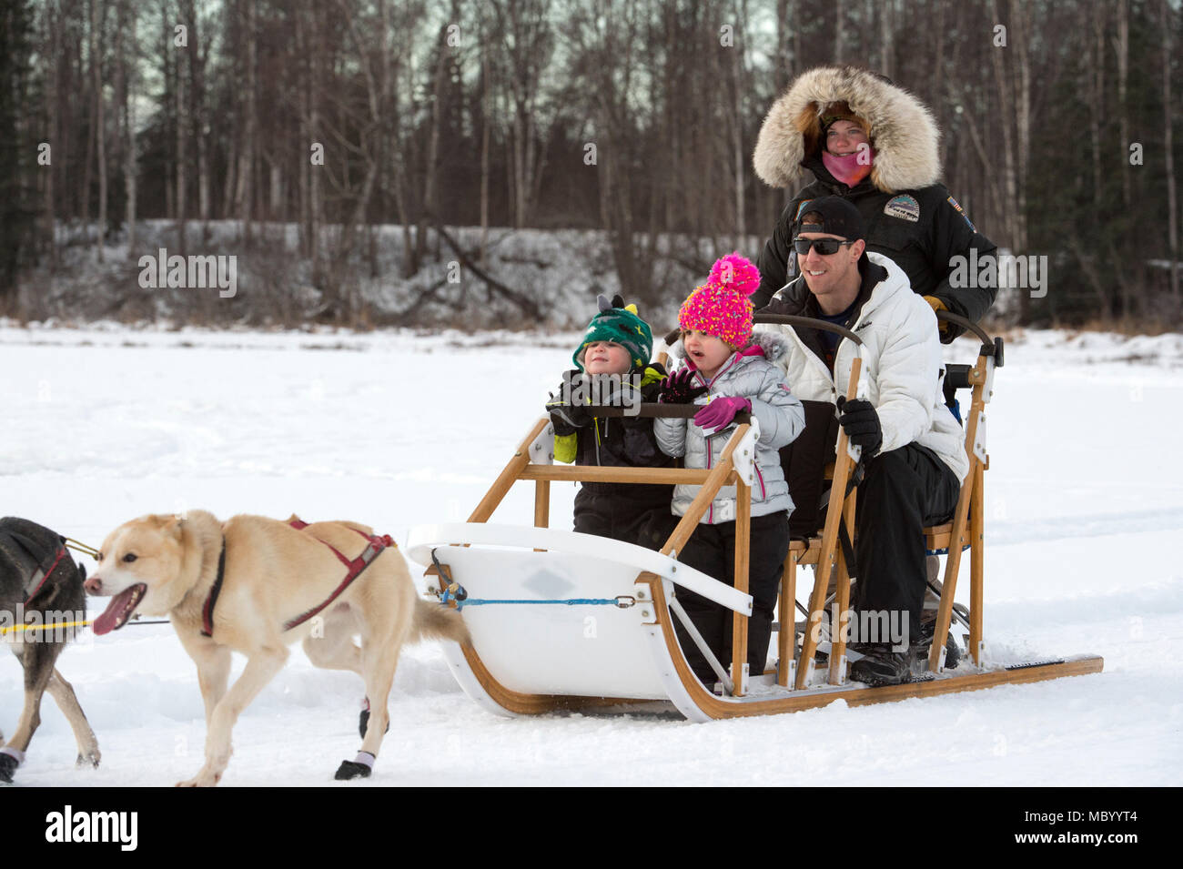Air Force Special Agent Roland Bodenheim und seine Kinder Merrick und Sloane, sowohl Alter 3, für einen Hundeschlitten Fahrt am Hillberg See am Joint Base Elmendorf-Richardson, Alaska, 14.01.2018. Bodenheim ist mit der Air Force Office der speziellen Untersuchungen. Als Teil der Moral, Wohlfahrt und Erholung Programm bewirtet durch die 673 d Force Support Squadron und JBER Life Team, die hillberg Skigebiet bietet die mit Base Access eine Vielzahl von Wintersportmöglichkeiten und Veranstaltungen. (U.S. Air Force Foto von Alejandro Peña) Stockfoto