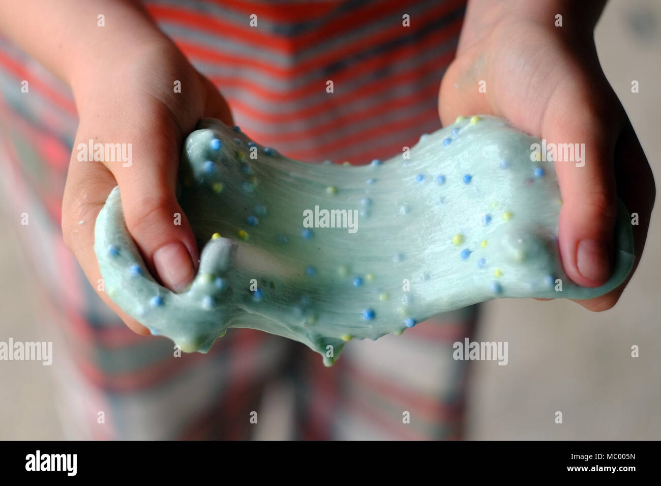 Kind mit hausgemachten Schleim. Die neuen Verrücktheit verwendet Borax und  PVA Leim und Farbe bunte Mischungen zu machen Stockfotografie - Alamy