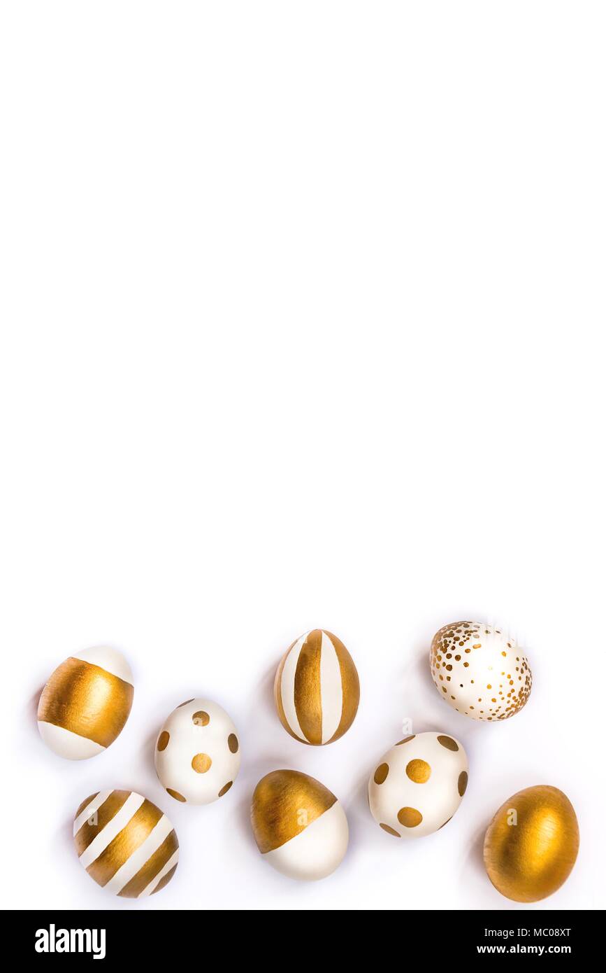 Blick von oben auf die Ostereier gefärbt mit goldenen Farbe in verschiedenen Mustern. Verschiedene gestreifte und gepunkteten Designs. Weißer Hintergrund. Kopieren Sie Platz. Stockfoto