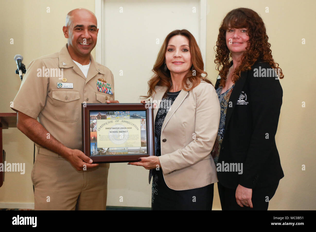 180117-N-RP 435-019 SAN DIEGO (Jan. 17, 2018) Kapitän Roy Liebe (links) kommandierender Offizier Naval Base San Diego (NBSD) und Chanin Massaglia (rechts), NBSD Schule Liaison Officer (SLO), Gegenwart Sweetwater Union School District Vertreter Miriam Duggan mit einer Bescheinigung der Anerkennung für die Unterstützung der Bildung von San Diego Bereich militärische Jugend. NBSD hosted mehrere Schule-betriebsleiter und Vertretern der Bezirke in San Diego Grafschaft für ein Briefing, die einen Überblick über die Flotte und NBSD Familie Programme und eine Diskussion darüber, wie die SLOs mit Bereich Schulen arbeiten können als auch im Preis inbegriffen Stockfoto