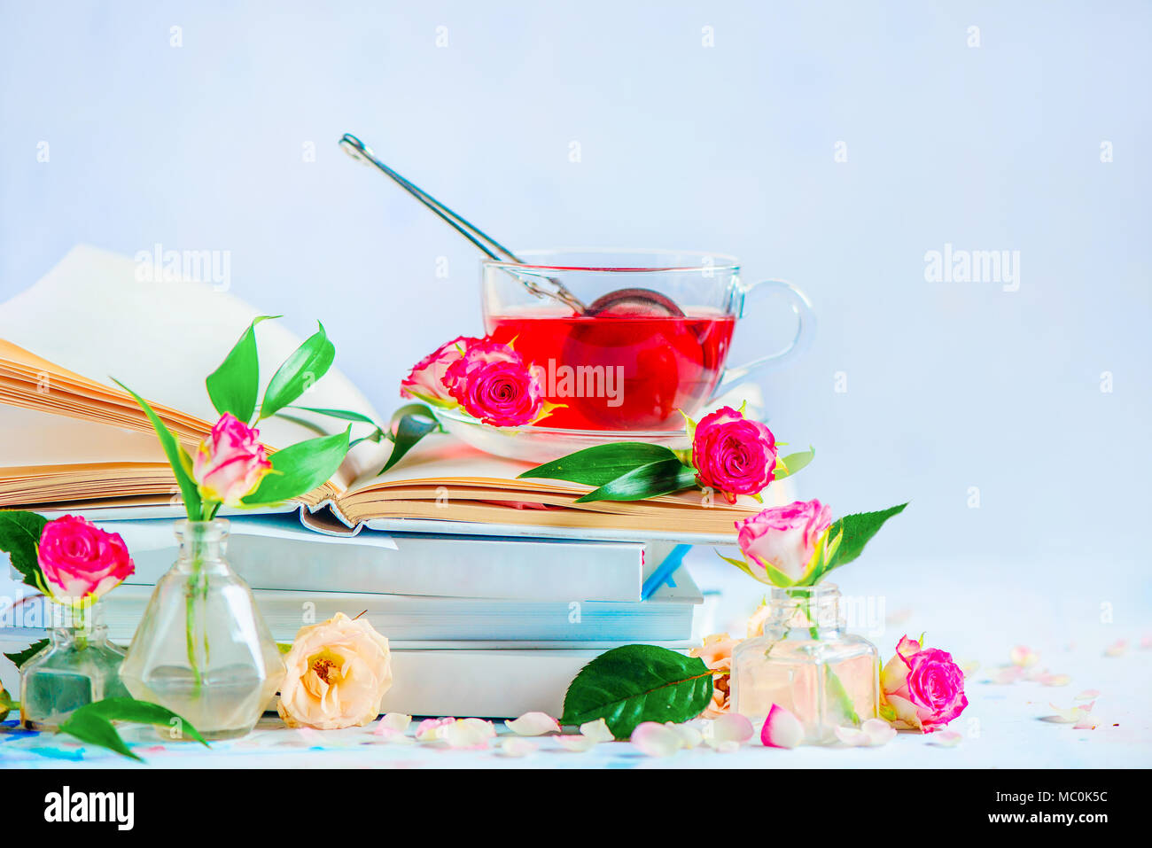 Rote Rosenblüten Tee auf einem Stapel weiß Bücher. Romantische Stillleben mit kopieren. Feder Freizeitaktivitäten und lesen Konzept. Stockfoto