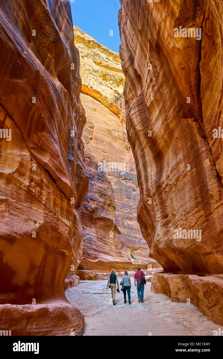 Touristen, die zu Fuß durch den Siq, Petra, Jordanien Stockfoto