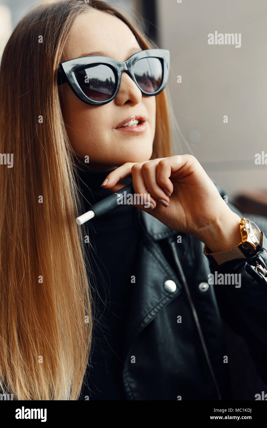 Mädchen sitzen in Caffee Ort und Rauch elektronische Zigarette eine Schutzbrille zu tragen. Stockfoto