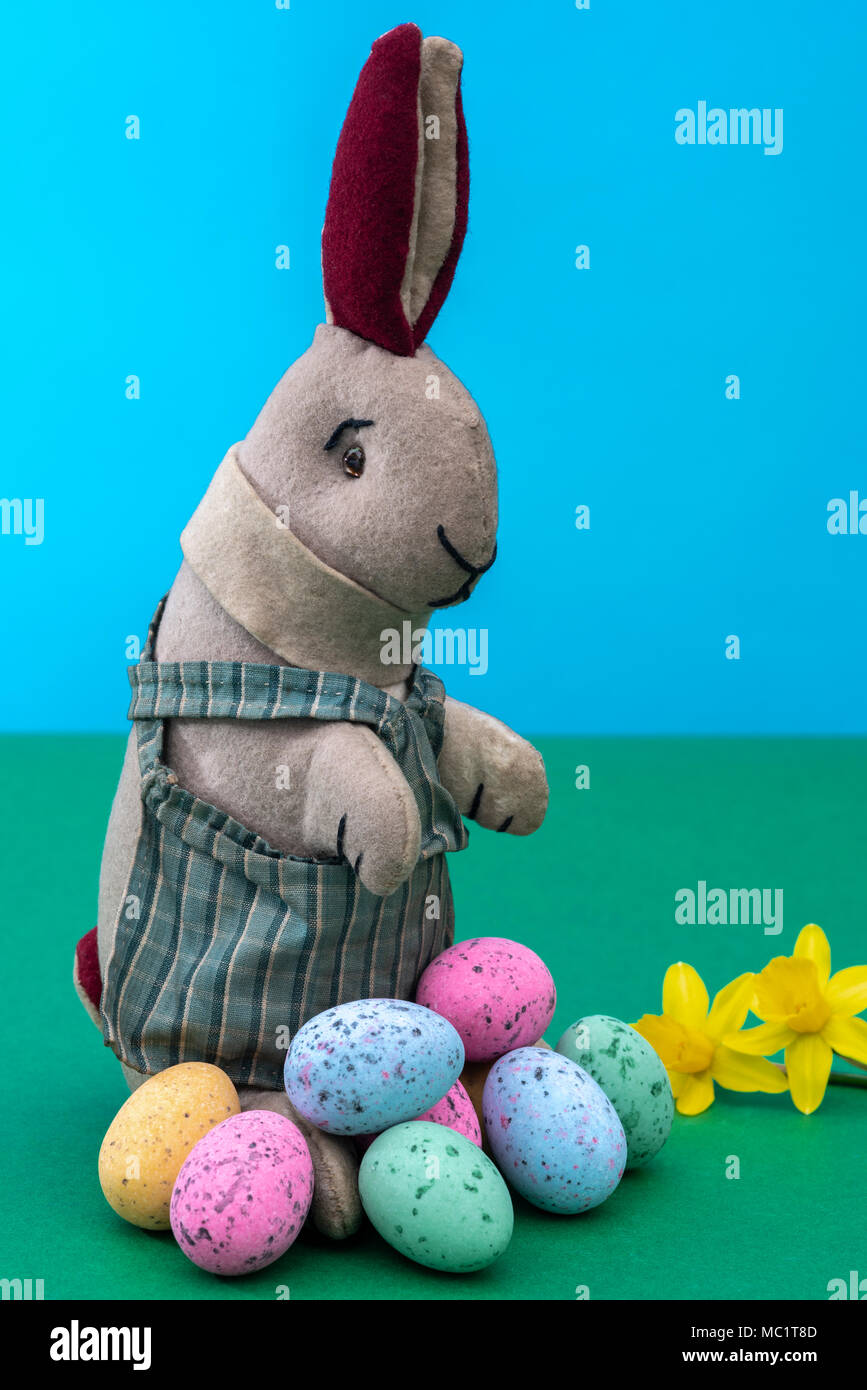Vintage Spielzeug Hase, Bunny, mit einem Stapel von Schokolade Ostereier. Stockfoto