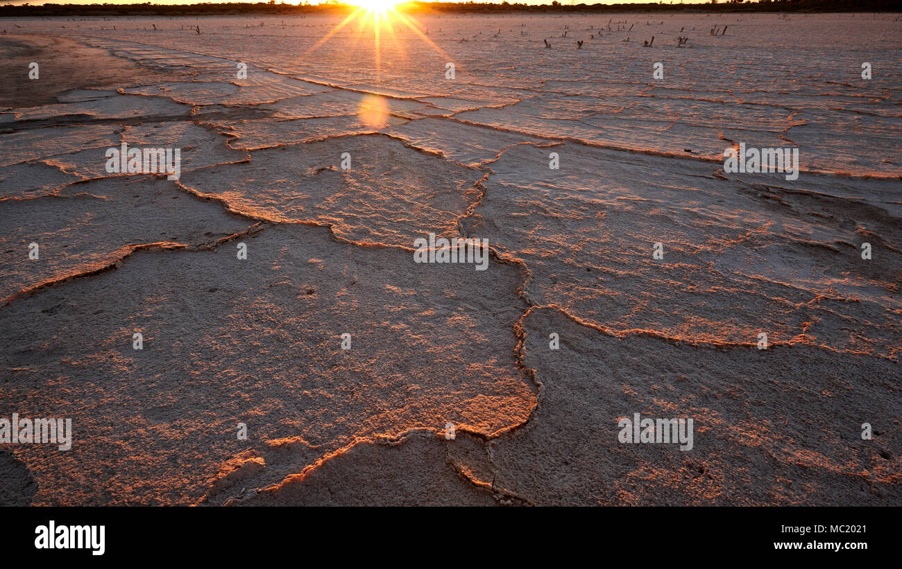 Salzkruste ans Meer und die untergehende Sonne in der Nähe von Merbein West, Victoria, Australien. Stockfoto