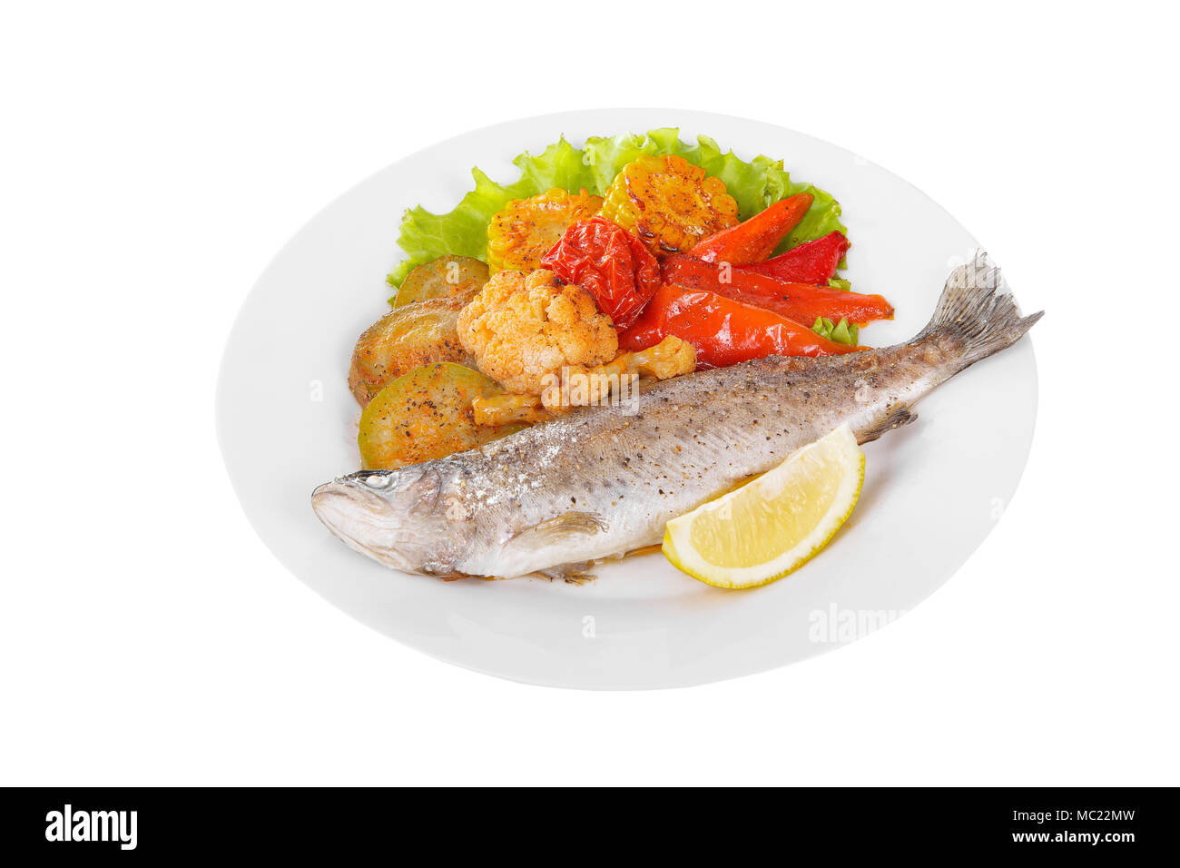 Fisch Forelle mit einem Kopf gebacken, gebraten über dem offenen Feuer mit Beilage Gemüse eine Scheibe Zitrone und Pfeffer Leckere saftige natürliche weiße Isolat Stockfoto