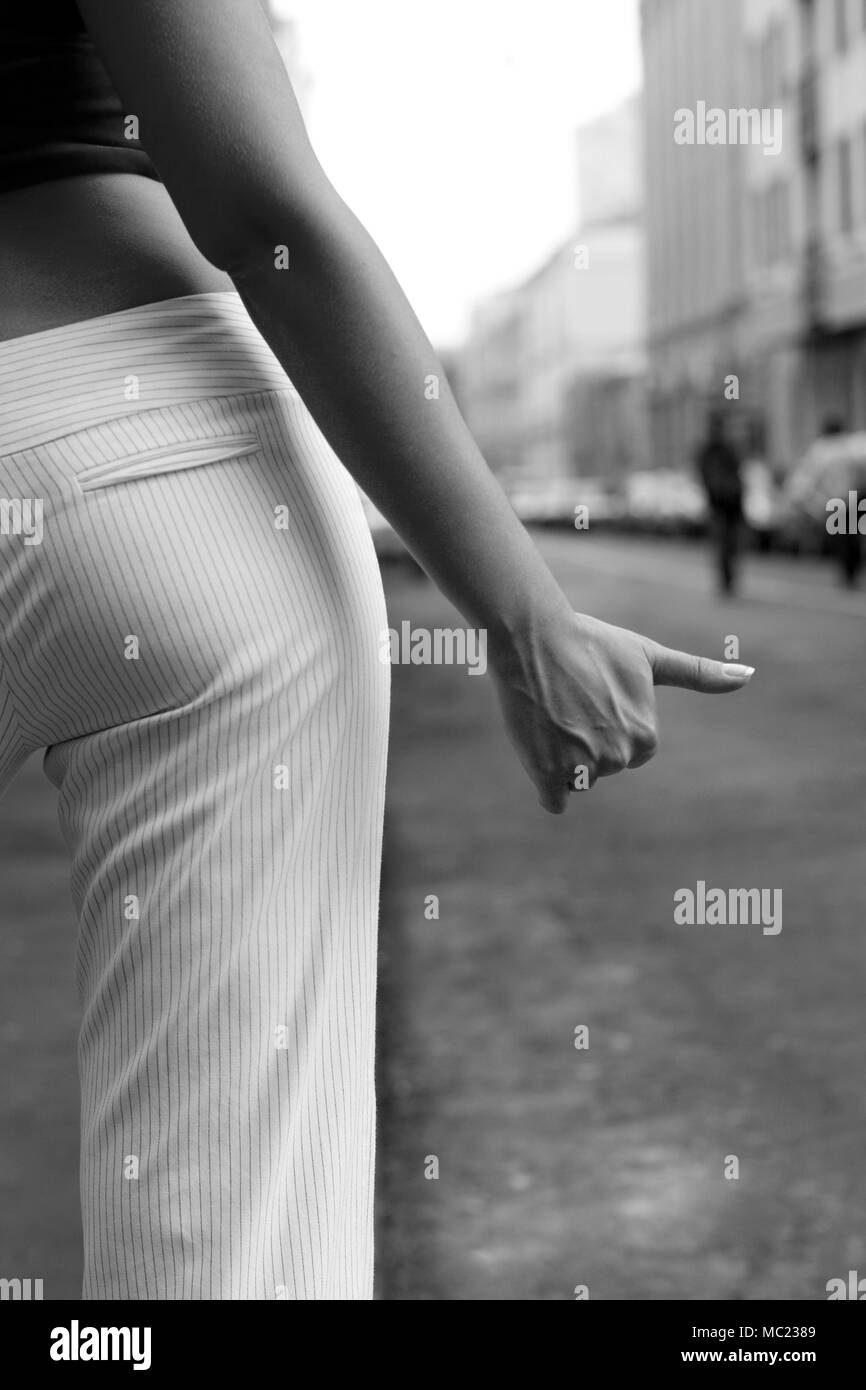 Schwarzweiß-Bild von Per Anhalter Mädchen auf der Straße Stockfoto