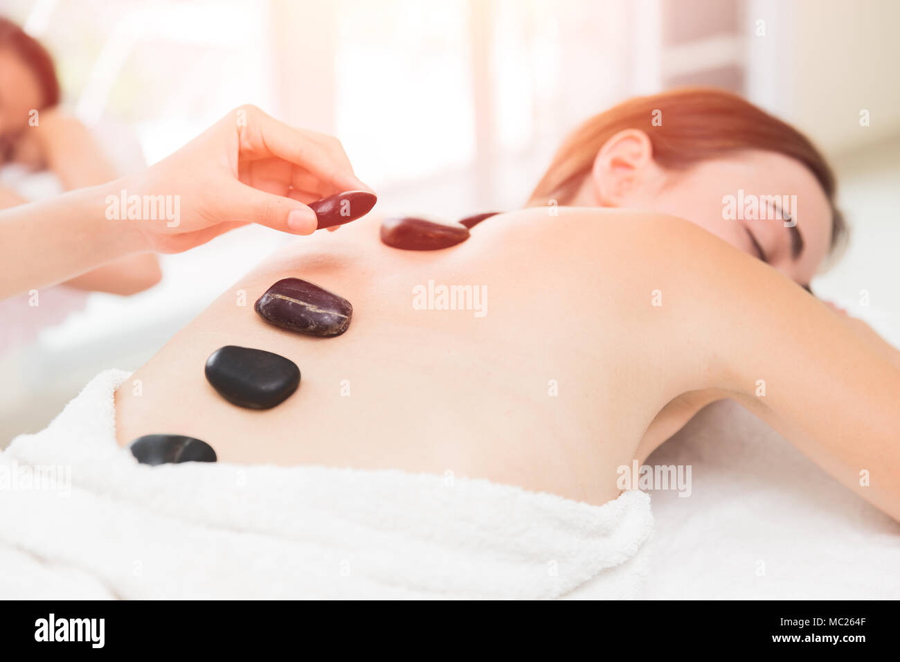 Warme und kalte Steine Massage im Spa für Rückenschmerzen Linderung und Entspannung Stockfoto