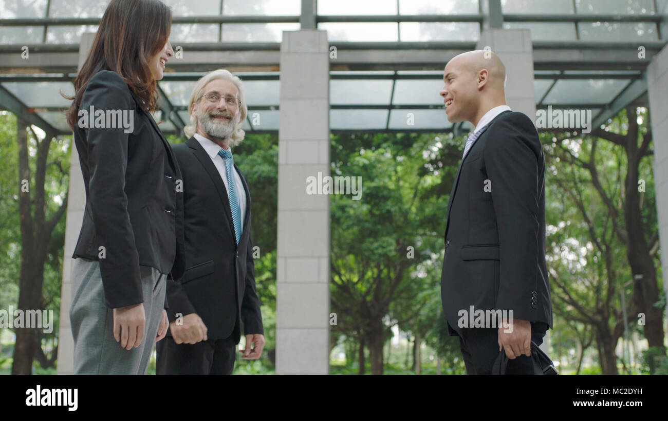 Drei corporate business Leute stehen und sprechen in der Lobby des modernen Bürogebäude. Stockfoto