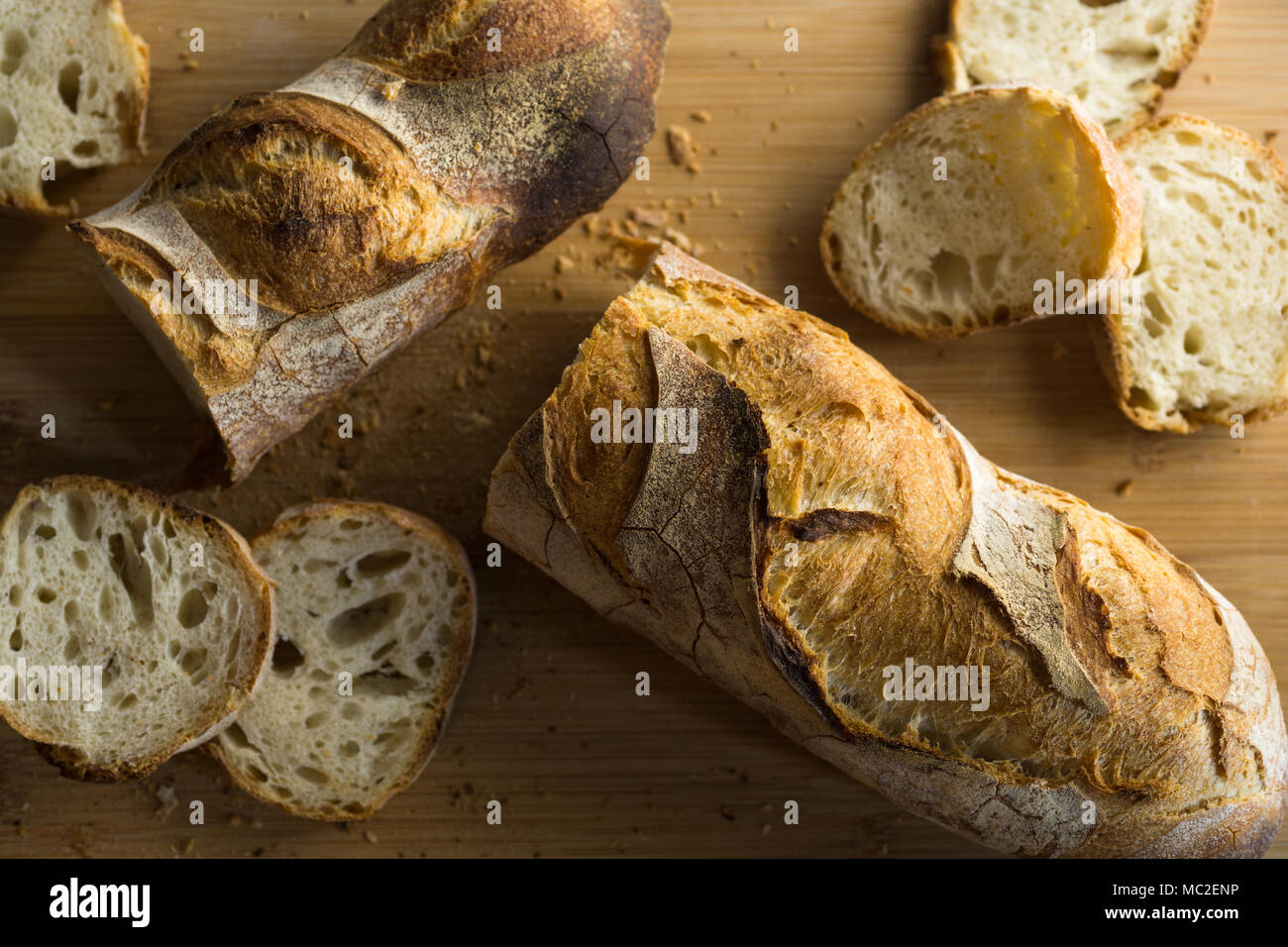 Französisches Brot - Baguette auf einem hölzernen Schneidebrett, Ansicht von oben geschnitten. Stockfoto
