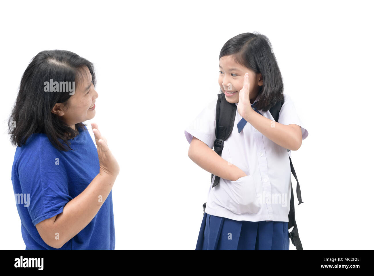 Asiatische Studenten in die Schule zu gehen und Abschied winkend zu ihrer Mutter auf weißem Hintergrund, zurück zu Schule Konzept Stockfoto