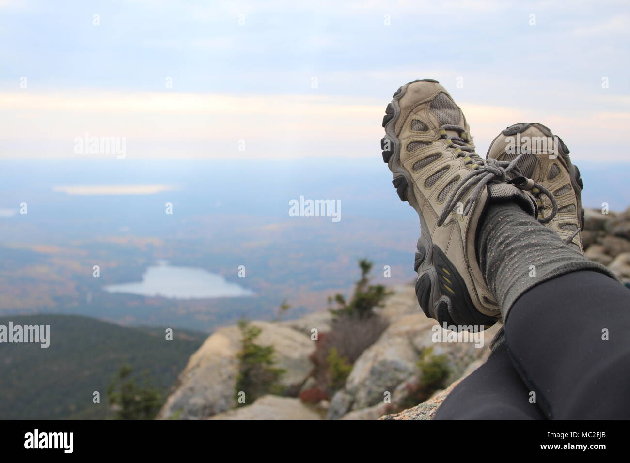 Wanderschuhe auf dem Gipfel des Mount Chocorua, in den White Mountains von New Hampshire. Ein Blick auf die Seen, Falllaub und bewölktem Himmel bilden die oberste. Stockfoto