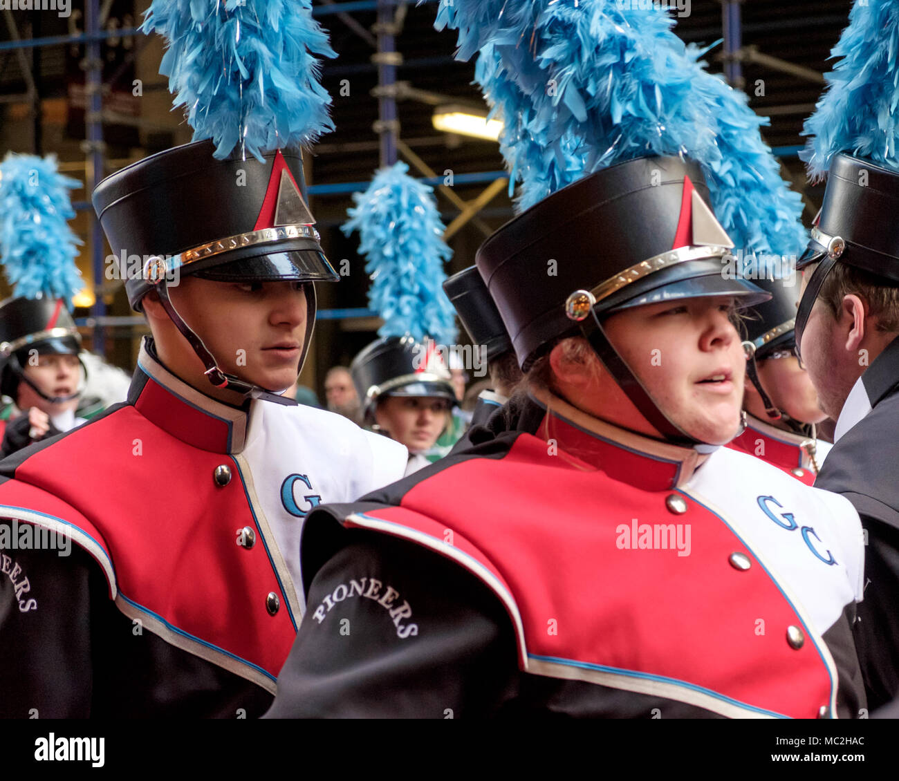 Zwei Jungen März in Band am St. Patrick's Day Parade, New York, 2018. Marching Band, Uniformen, schwarze Hüte, blau Federn, roten, weißen und schwarzen Uniformen. Stockfoto