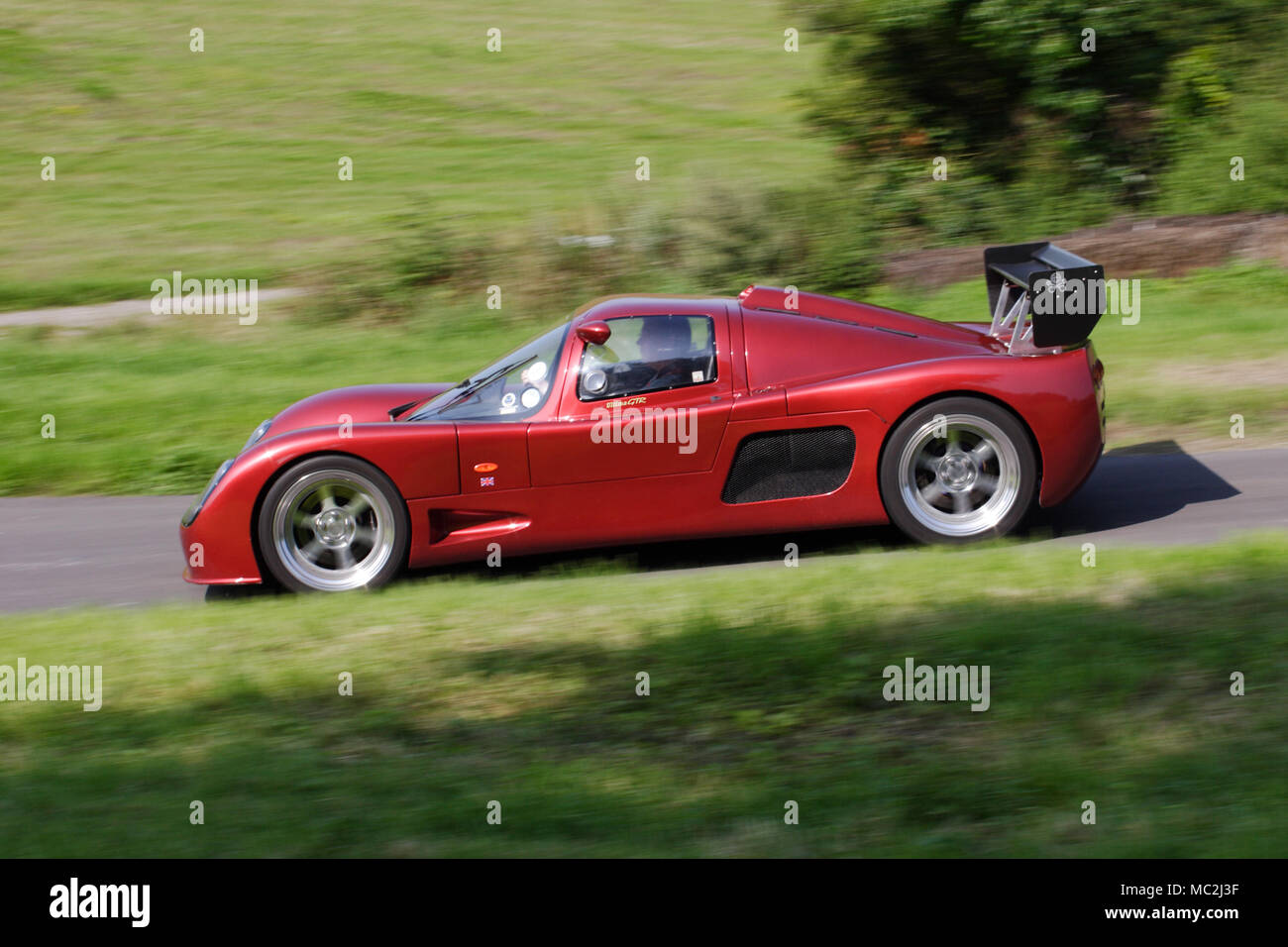 Red scarlet Ultima GTR im Profil (Seitenansicht) schnelles Fahren auf einer Landstraße. Stockfoto