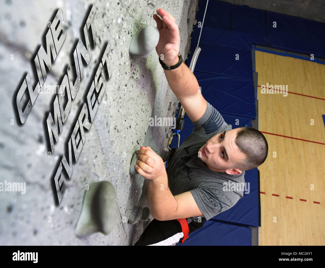 Airman 1st Class Kevin Morrissey, 91st Security Forces Squadron Response Force Mitglied, klettert eine Felswand in der McAdoo Fitnesscenter am Minot Air Force Base, N.D., 23.01.2017. Die McAdoo Fitnesscenter bewirtet ein Selbststudium fitness Herausforderung Mount Everest, die erfordert, dass Sie die Wand zu klettern 1.569 Mal den Gipfel zu erklimmen. (U.S. Air Force Foto Illustration von Airman 1st Class Dillon J. Audit) Stockfoto