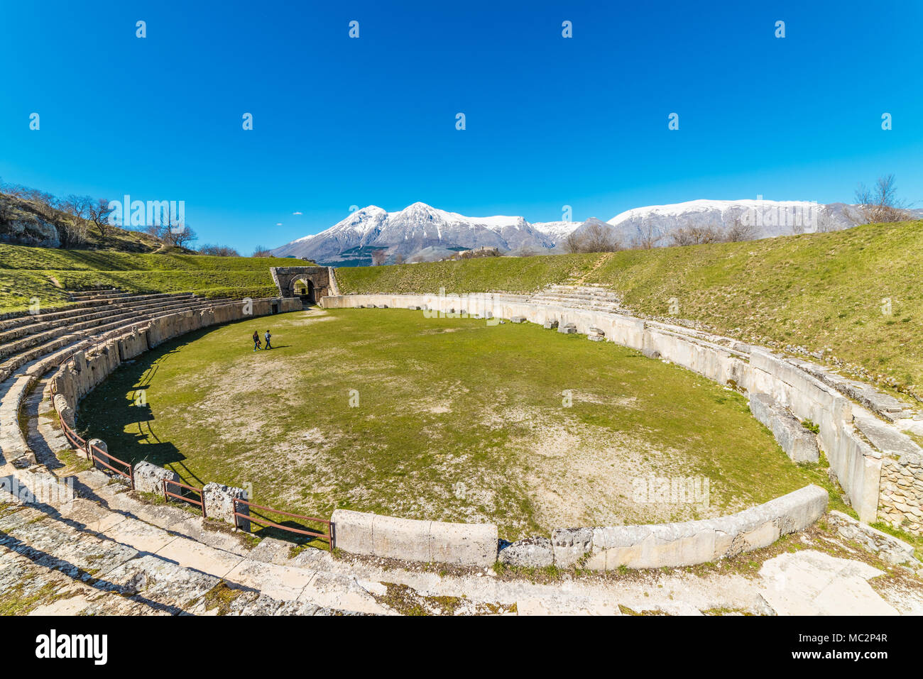 Alba Fucens (Italien) - Eine eindrucksvolle römische Ausgrabungsstätte mit Amphitheater, in einem öffentlichen Park vor Monte Velino Berg mit Schnee, Abruzzen Stockfoto