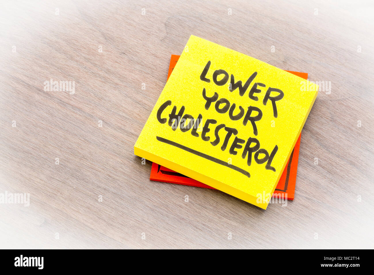 Senken Sie Ihre Cholesterin Erinnerung Hinweis gegen gemasertem Holz board Stockfoto
