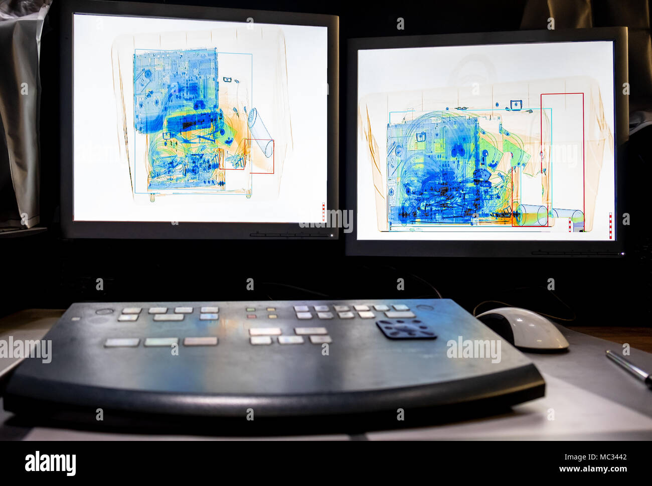 X-ray system Scannen von einem Kasten mit einer Sprayflasche, eine Flasche Wasser, einen Laptop und eine Kameratasche. Stockfoto